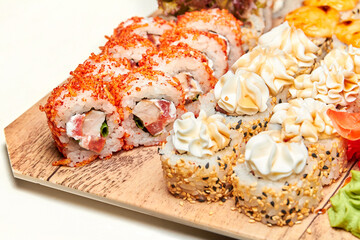 Set of various sushi rolls on a board. Close-up, selective focus