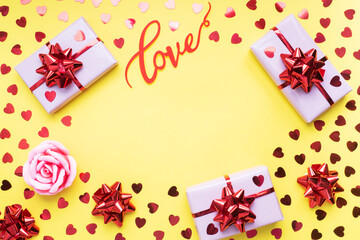 Valentine day composition, Greeting gift box with confetti hearts on yellow background. Flat lay.