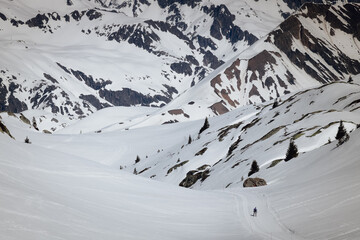 silhouette d'une personne se promenant en altitude à l'alpe d'huez en hiver avec de la neige qui fond - obrazy, fototapety, plakaty