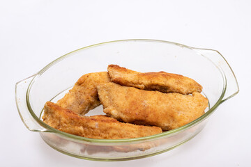 Breaded fish fillets in a glass, heat-resistant dish