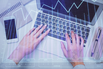 Double exposure of woman hands working on computer and forex graph hologram drawing. Top View. Financial analysis concept.