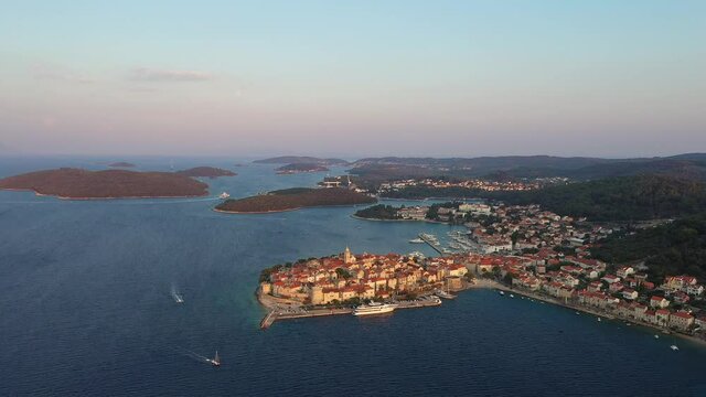 Aerial footage of the sunset over the stunning Korcula island and old town by the Adriatic sea in Croatia in the Balkans in summer. Shot with a drone and rotation motion. 