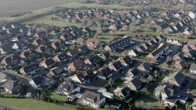 Suburb with new single-family houses on the edge of a large city with farmland in the surrounding area
