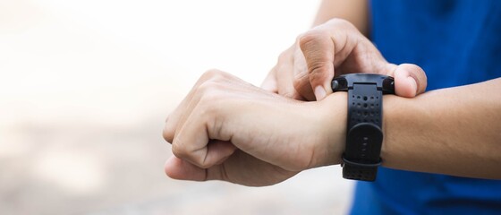Close-up sporty man hand with watch for check statistic or heart rate.After finishing exercise.Fitness and healthy lifestyle concept.