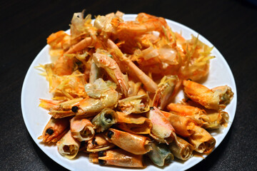 Leftovers from shrimp on a white plate.