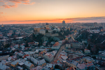 Obraz premium Veszprém, Hungary - Amazing aerial view of Veszprém downtown and castle district on a winter morning with stunning golden sunrise. Historical old buildings, church and much more.
