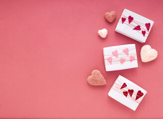 White wrapped gift boxes on pink background with braid and hearts with copy space