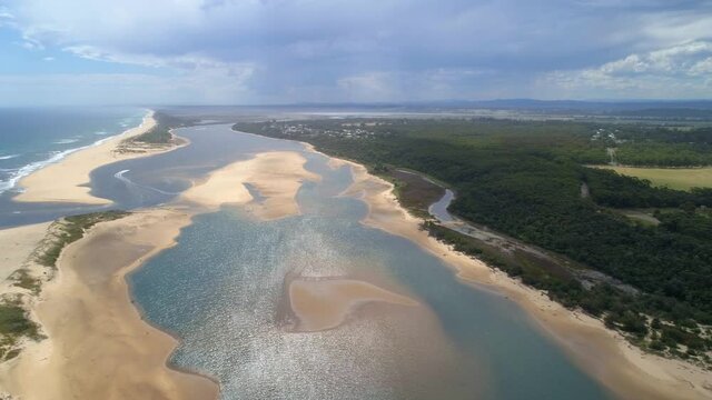 Aerial pan across Snowy River estuary revealing scenic countryside near Marlo, Australia