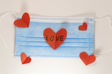 red heart on a mask on valentine's day on a white isolated background. heart surgical mask with place for inscription, mock up, copy space