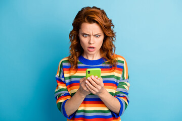 Portrait of furious lady look phone screen dislike open mouth striped sweater isolated on blue...