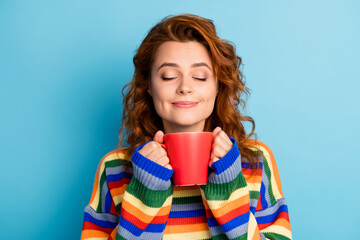 Close up portrait of curly hairstyle person closed eyes hold cup wear pullover isolated on blue color background