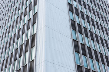 Looking up tall glass and concrete office high-rise building.