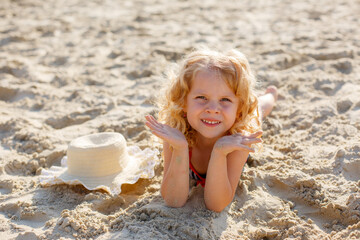 little girl lying on the beach on the sand summer