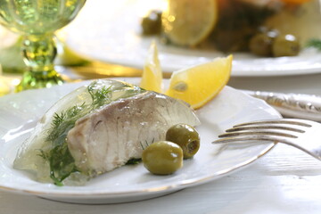 Jellied sturgeon with lemon, olives and glasses of white wine