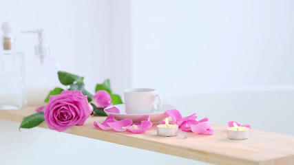 Fototapeta na wymiar Beautiful spa setting with pink candle and flowers on wooden background. Concept of spa treatment in salon. Atmosphere of relax, serenity and pleasure. Luxury lifestyle.