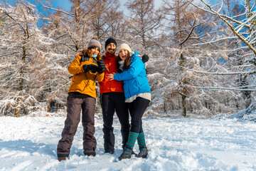 Three friends enjoying in the snowy forest in the month of January the Artikutza natural park in...