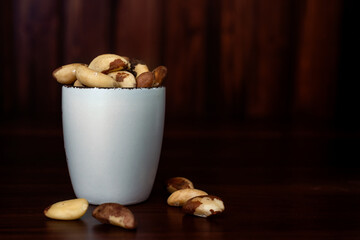 Bowl with Brazilian nuts on wooden table. Brazil nut or Bertholletia