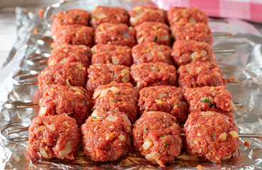 raw meat skewers with minced meat lined up