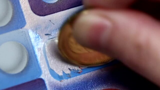 Close up woman scratching a lottery ticket at extra section