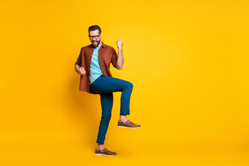 Fototapeta na wymiar Full length body size photo of funny hipster in casual clothes gesturing like winner yelling isolated on vibrant yellow color background