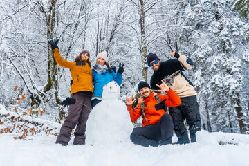 Some friends with a snowman in the snowy forest of the Artikutza natural park in oiartzun near San...