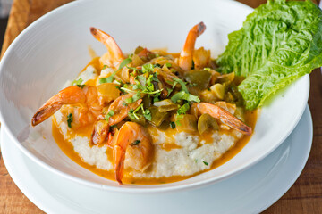 Shrimp and Grits. Grits and old bay seasoned jumbo shrimp topped with spices and micro greens. Classic American Diner Style Breakfast or Brunch menu item. Traditional low country southern staple. 