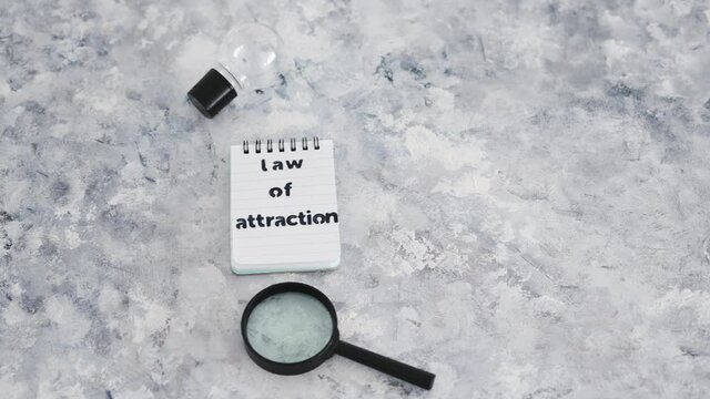 law of attraction notepad with light bulb and magnifying glass symbol of introspection and mindset shift