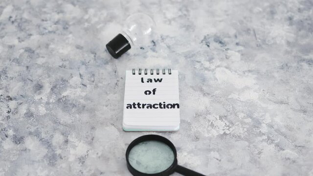 law of attraction notepad with light bulb and magnifying glass symbol of introspection and mindset shift