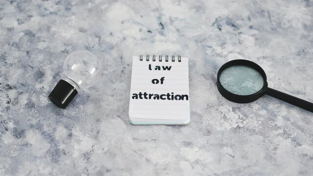 law of attraction notepad with light bulb and magnifying glass symbol of introspection and mindset shift