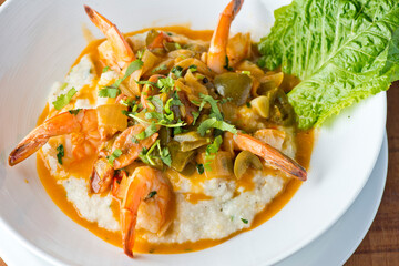 Shrimp and Grits. Grits and old bay seasoned jumbo shrimp topped with spices and micro greens. Classic American Diner Style Breakfast or Brunch menu item. Traditional low country southern staple. 