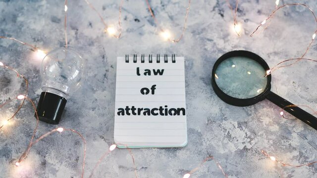 law of attraction notepad with light bulb and magnifying glass symbol of introspection and mindset shift