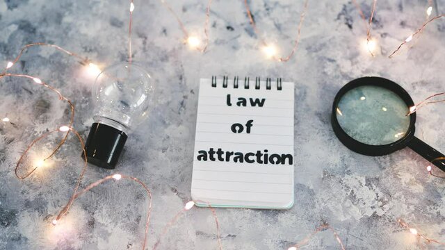 law of attraction notepad with light bulb and magnifying glass symbol of introspection and mindset shift