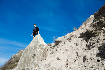 young man in black clothes climbing up the mountain