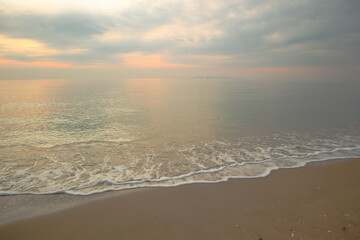 Beautiful sand beach background with soft wave in the morning.