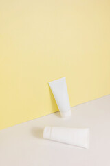 a set of cosmetic tubes on a combined white-beige background. Minimalistic cosmetic concept. Copy space
