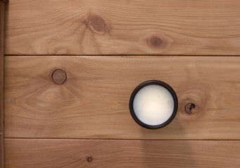 Drinking yogurt in a dark-colored ceramic cup on a wooden table. The view from the top