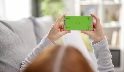Smartphone with green markered screen holding by woman