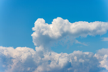 Naklejka na ściany i meble Closeup of a puffy white clouds in a clear blue sky, cumulonimbus. Photography, full frame.