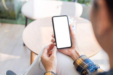 cell phone blank white screen mockup.woman hand holding texting using mobile on desk at...