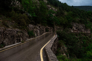 Asphalt road through the mountains forest in rainy season
