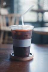 A plastic glass of iced americano coffee mix with fresh orange juice