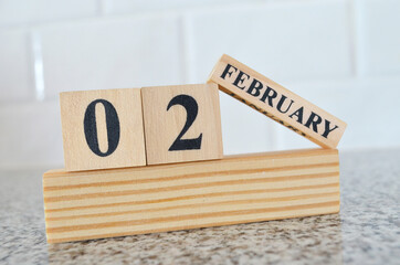 February 2, Cover design with number cube on a white background and granite table.