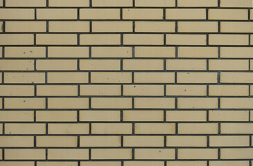 Obraz premium Part of the wall is made of beige brick with spots