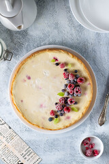 open pie cheesecake with berries on a light background