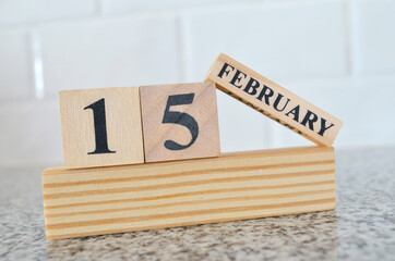 February 15, Cover design with number cube on a white background and granite table.