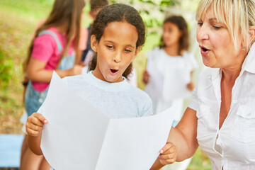 Teacher practices acappella singing with girls