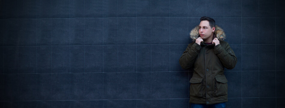 Portrait Of Young Man With Anorak On Black Wall