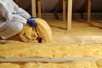 Worker insulate the attic with mineral wool