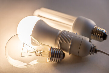 LED bulb on with fuorescent bulb and incandescent bulb next to it. Evolution of light bulbs.