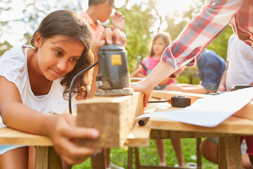 Children sanding wood in teamwork